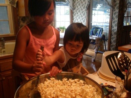 Kasen and Karis making Daddy's popcorn cake